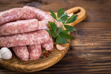 Raw sausages on the wooden board