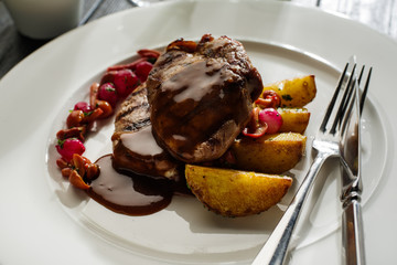 Grilled pork medallions with pickled mushrooms and roasted potatoes.