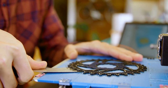 Mechanic taking out chain ring from die machine in workshop 4k