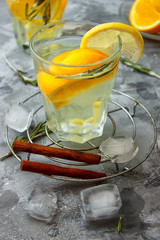 Cold ginger tea with orange and lemon in glass cups. Tea with ice. The decor. Cinnamon and Rosemary Spices