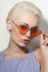 Obraz premium Vintage style portrait of young beautiful woman with stylish sunglasses