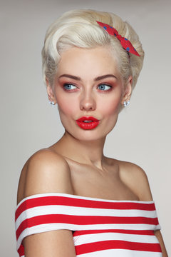 Vintage style portrait of young beautiful blond woman in striped top