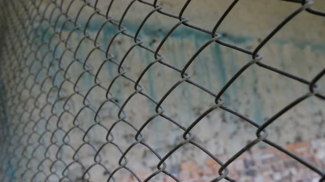 Metal wire fence in industrial workshop. Slider shot. Texture
