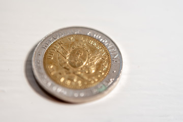 Macrophotography of one Argentine peso coin on a white background