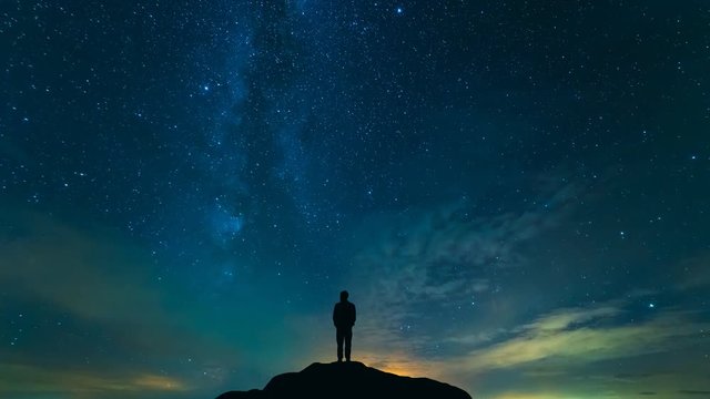 The man standing on the rock with a cloud stream background. time lapse