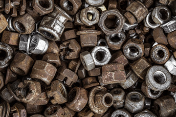 Metal screw-nuts in set. Spent fasteners background.