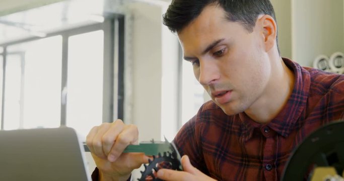 Mechanic checking diameter of chain ring with vernier calipers 4k