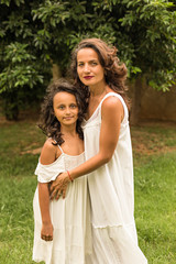 Fototapeta premium Beautiful mother and daughter in white dresses.