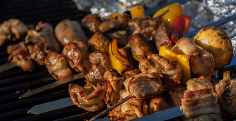 Close up of Chicken, Beef, Bacon and Potatoes Skewers on  Barbecue