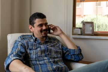 young man talking by phone at home