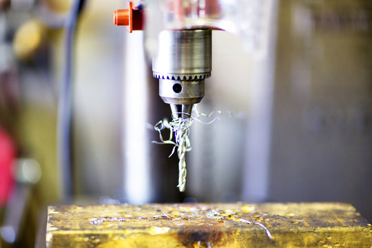 Close up of drill machine on rusty metal in factory