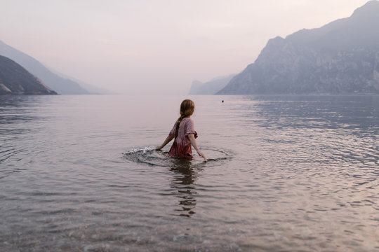 Woman in water at Lake Garda Italy at dusk
