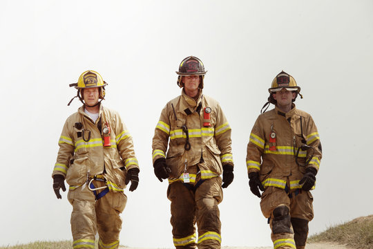 Three firefighters walking on road