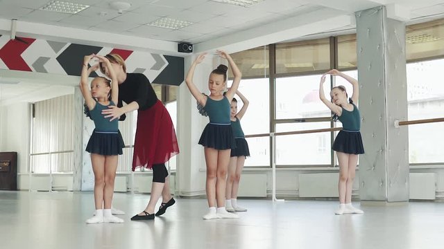 ballet teacher straightens little ballerina. children in ballet class in ballet class