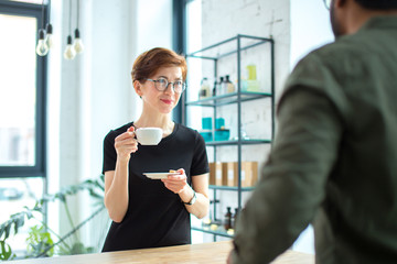 two Business People Chatting while dring coffee in office