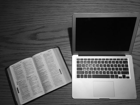 laptop and bible on table