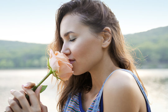 Side view of woman smelling rose
