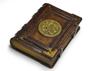 Large luxury leather - wooden book with a gilded transmutation circle in center of the front cover, attributed to a German alchemist from the 17th century. It laying on the table, angled on the righ. 