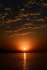Beautiful blazing sunset landscape at Caspian Sea and orange sky above.