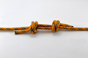 nodo inglese doppio arrampicata, corda arancione isolato fondo bianco