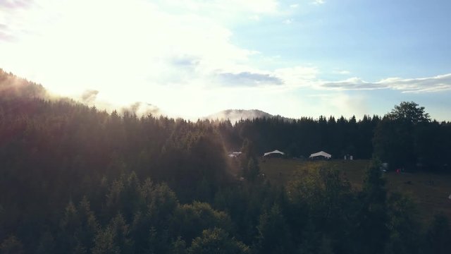 Aerial Shot Showing Valley Fog Move through the Mountains and a Romanian Festival and Campground