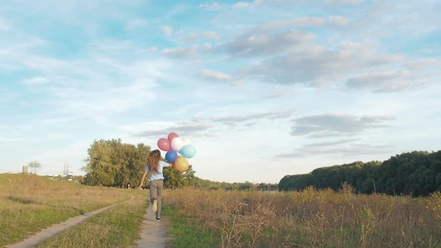 The child runs with balloons.