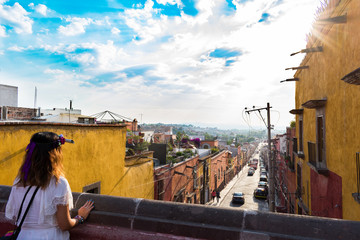 Girl with flower crown looking out at sunset at San Miguel de Allende Mexico