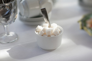a white cup of sugar cubes raffinate
