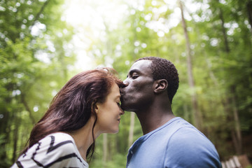 Fototapeta premium Side view of man kissing woman's forehead