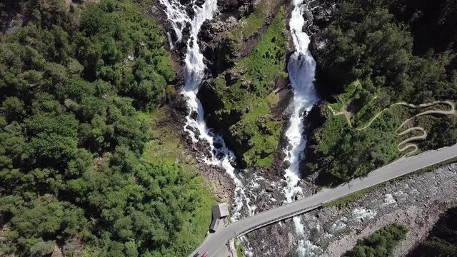 Aerial top to down view of Langfossen waterfall in Norway on a sunny summer day. Cars passing by the road situated next to the waterfall