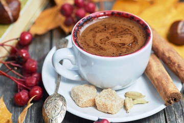 Hot steaming cup with coffee. Autumn fall leaves.