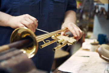 Midsection of man making trumpet in workshop © Cavan for Adobe