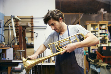 Man shaping trumpet in workshop © Cavan for Adobe
