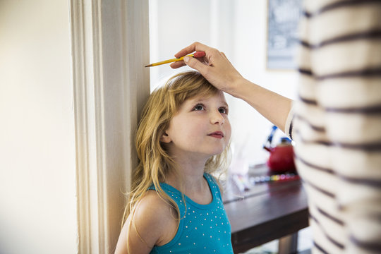Woman measuring daughter's height