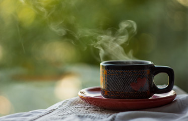 cup of coffee on wooden table in garden