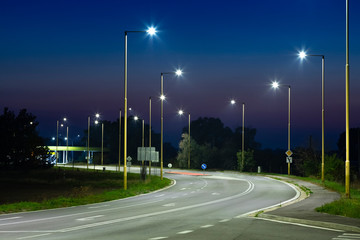 night empty road with modern LED street lights, entrance to a small town