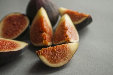 Freshly picked and cut figs on grey background.