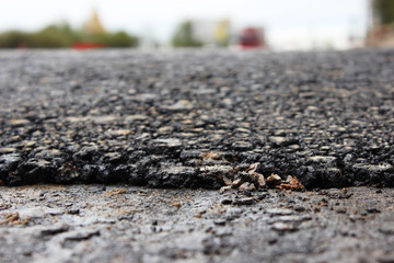 texture of fresh hot black asphalt is laid on the new automotive road edge of rolling.