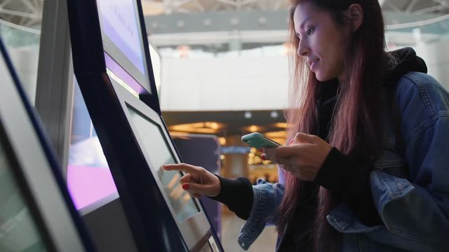 Young Tourist Woman Doing Self Check In And Using Desk Screen Terminal In Airport. 4K.