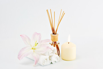 Spa decoration with candles, towels and aromatherapy oil bottle on white background. Copy Space. Relaxation and meditation concept, Greeting card to women's day