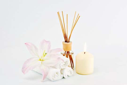 Spa decoration with candles, towels and aromatherapy oil bottle on white background. Copy Space. Relaxation and meditation concept, Greeting card to women's day