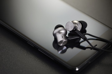 Earbuds on black smartphone
