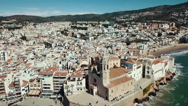 Aerial view of Sitges small town with church on Mediterranean coastline, Spain