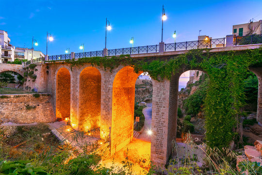 Polignano a Mare, Puglia, Italy: Ponte di Polignano bridge with Bastione di Santo Stefano and Lama Monachile beach in background, Apulia, Italy, Cala Paura gulf, province of Bari