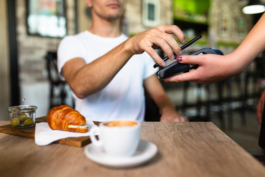 Payment transaction with smartphone in a snack bar.