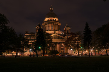 Fototapeta na wymiar View of St. Isaac's Cathedral from the Alexander Garden in the dark. The cathedral is beautifully illuminated. St. Petersburg. Russia.