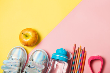 Children clothesand study stuff: sneackers, pencils, bottle of water and electron gps watches.