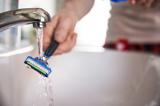 Close up of man washing razor