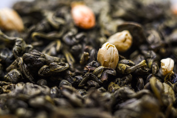 Dried green tea leaves with jasmine flowers - macro shot. Jasmine Green Tea background.