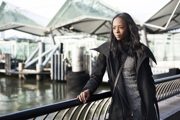 Obraz premium Woman looking away while standing by railing against river